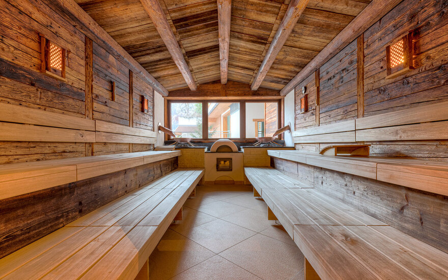 Ein gemütlicher Saunaraum mit Holzverkleidung, der eine entspannende Atmosphäre und große Fenster bietet.