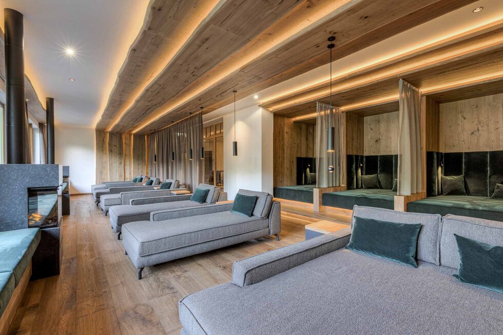 Ein eleganter Ruheraum mit modernen Liegen, sanfter Beleuchtung und Holzverkleidung, ideal für Entspannung und Erholung.