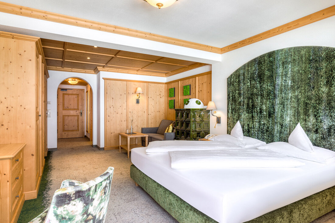 Ein gemütliches Schlafzimmer mit einem großen Doppelbett, umgeben von warmen Holzwänden und sanfter Beleuchtung.