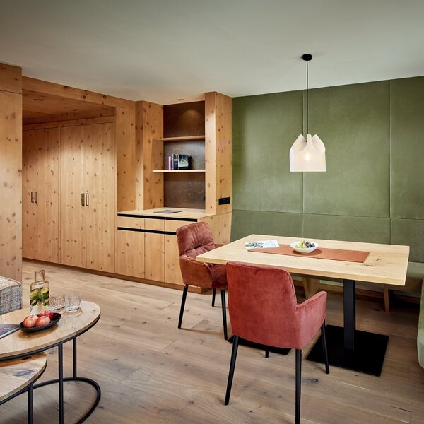 Ein modernes Esszimmer mit Holzverkleidung, einem großen Tisch und gemütlichen Stühlen in sanften Farben.