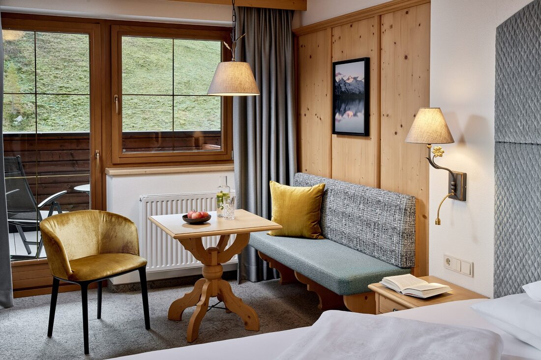 Ein gemütlicher Raum mit Holzverkleidung, einem Sofa und einem Tisch, der mit Äpfeln und einem Glas Wasser dekoriert ist.