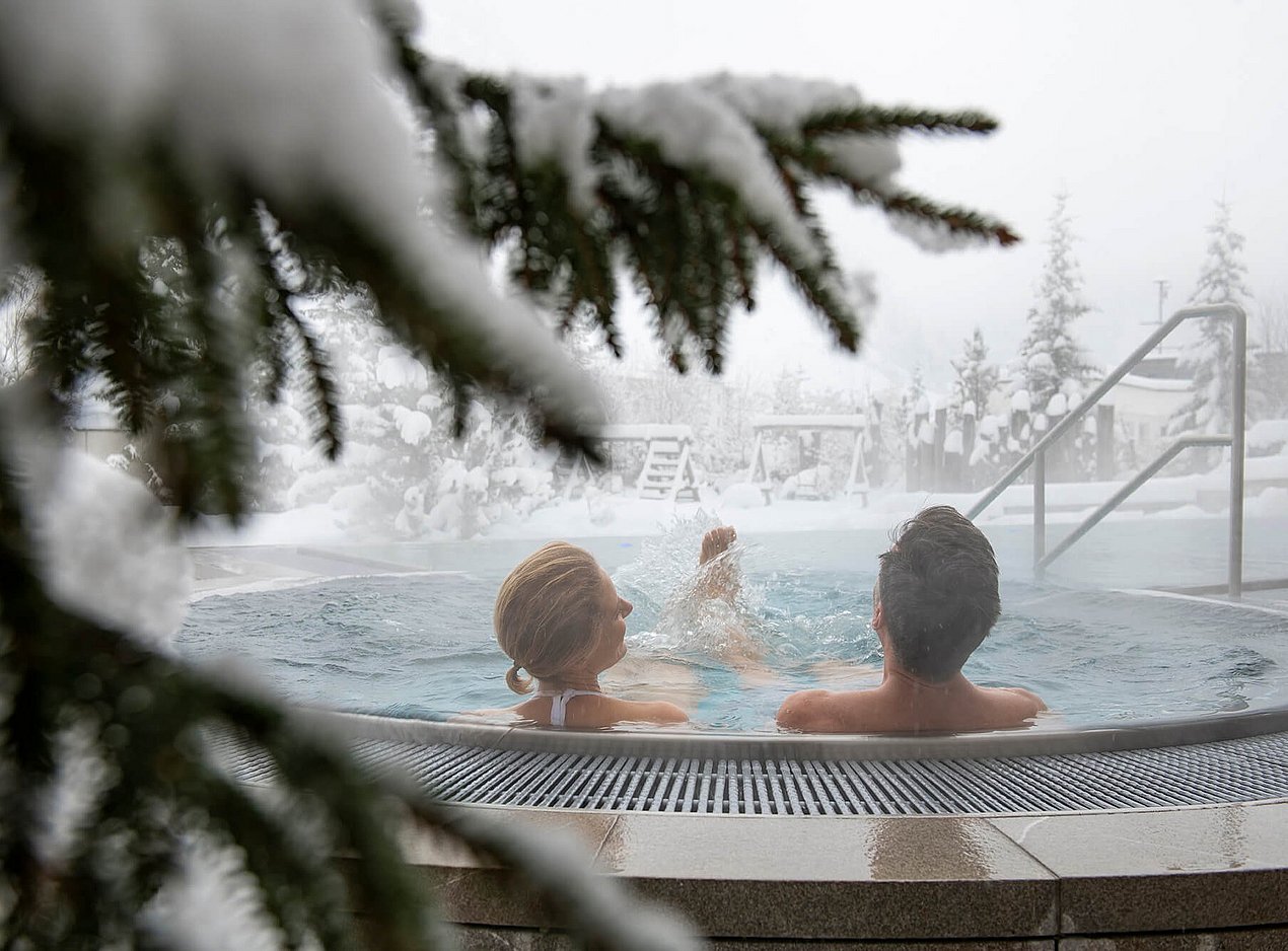 Paar im Whirlpool im Winter
