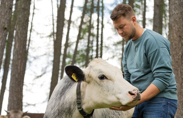 Maximilian Stock bei den Kühen auf der Wiese