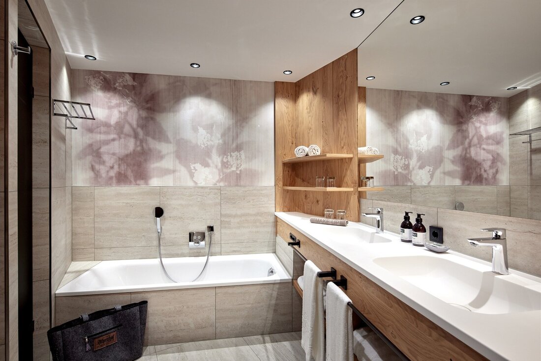 Ein modernes Badezimmer mit einer eleganten Badewanne und einem stilvollen Waschbecken aus Holz und Stein.