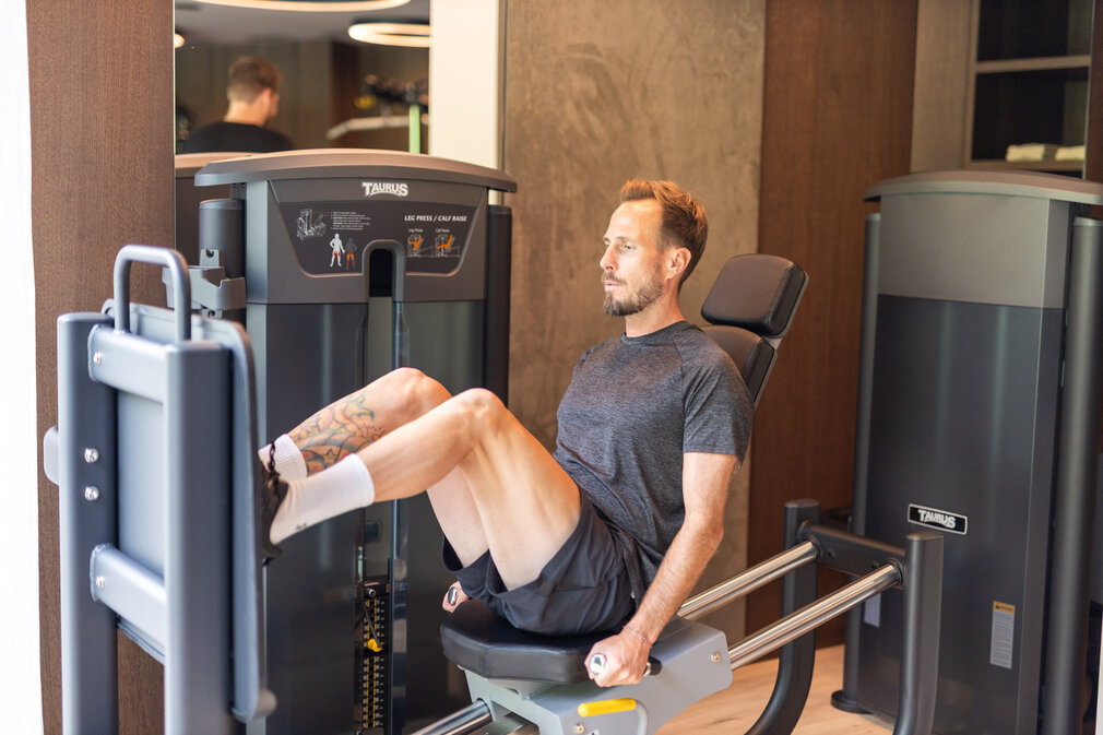 Ein Mann trainiert seine Beine im Fitnessstudio.