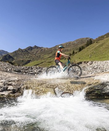 Mountainbiker an Gebirgsbach