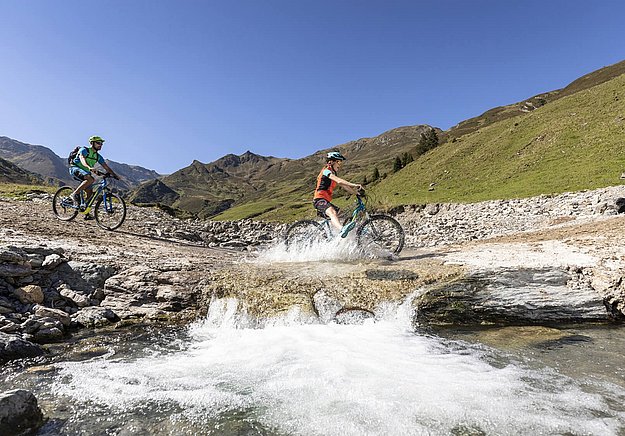 Mountainbiker an Gebirgsbach