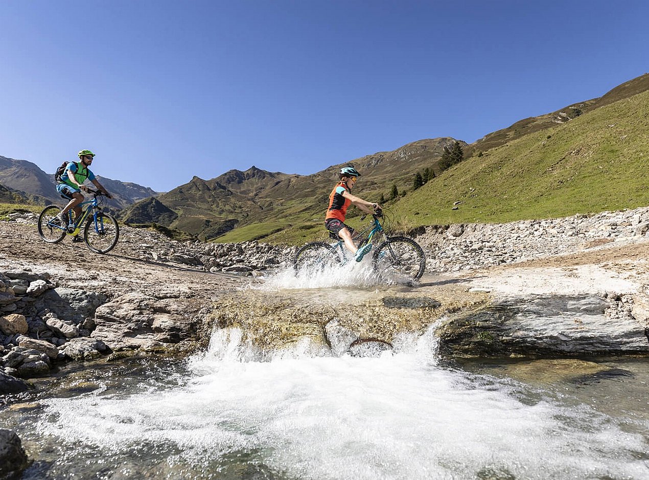 Mountainbiker an Gebirgsbach