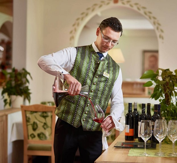 Kellner gießt Wein ein