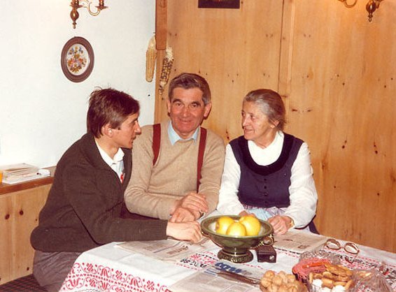 3 Personen sitzen an Tisch