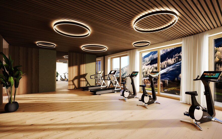 Ein modernes Fitnessstudio mit eleganten Geräten und großen Fenstern, die einen Blick auf die Alpenlandschaft bieten.