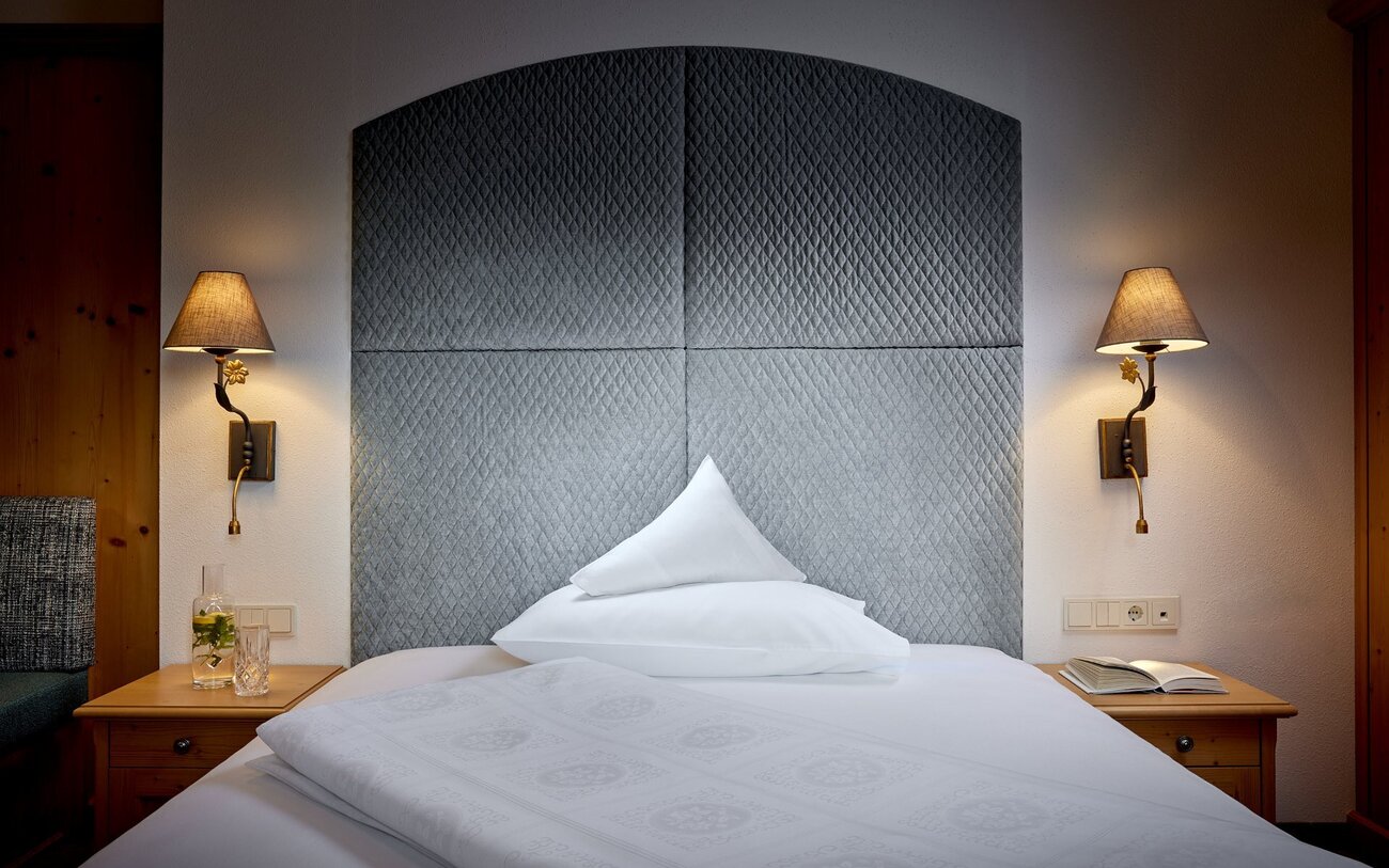 Ein stilvolles Schlafzimmer mit einem gepolsterten Kopfteil und einem Kissen, das auf dem Bett liegt, sorgt für eine einladende Atmosphäre.