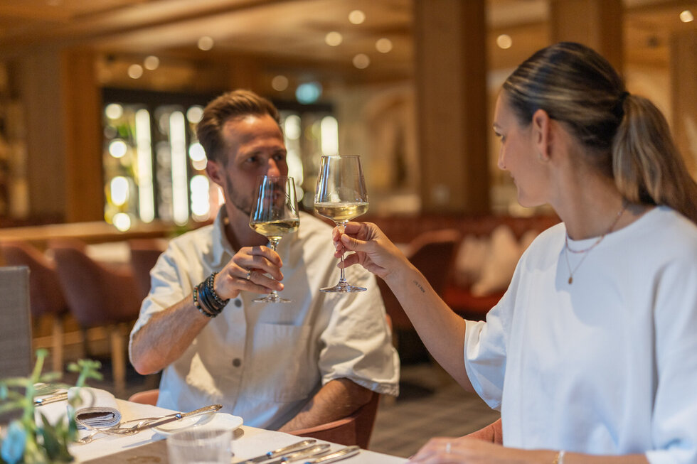 Ein Mann und eine Frau genießen en Glas Weißwein.