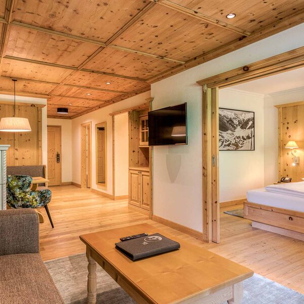 Ein gemütliches Schlafzimmer mit Holzvertäfelung, einem großen Bett und einem Fernseher an der Wand.