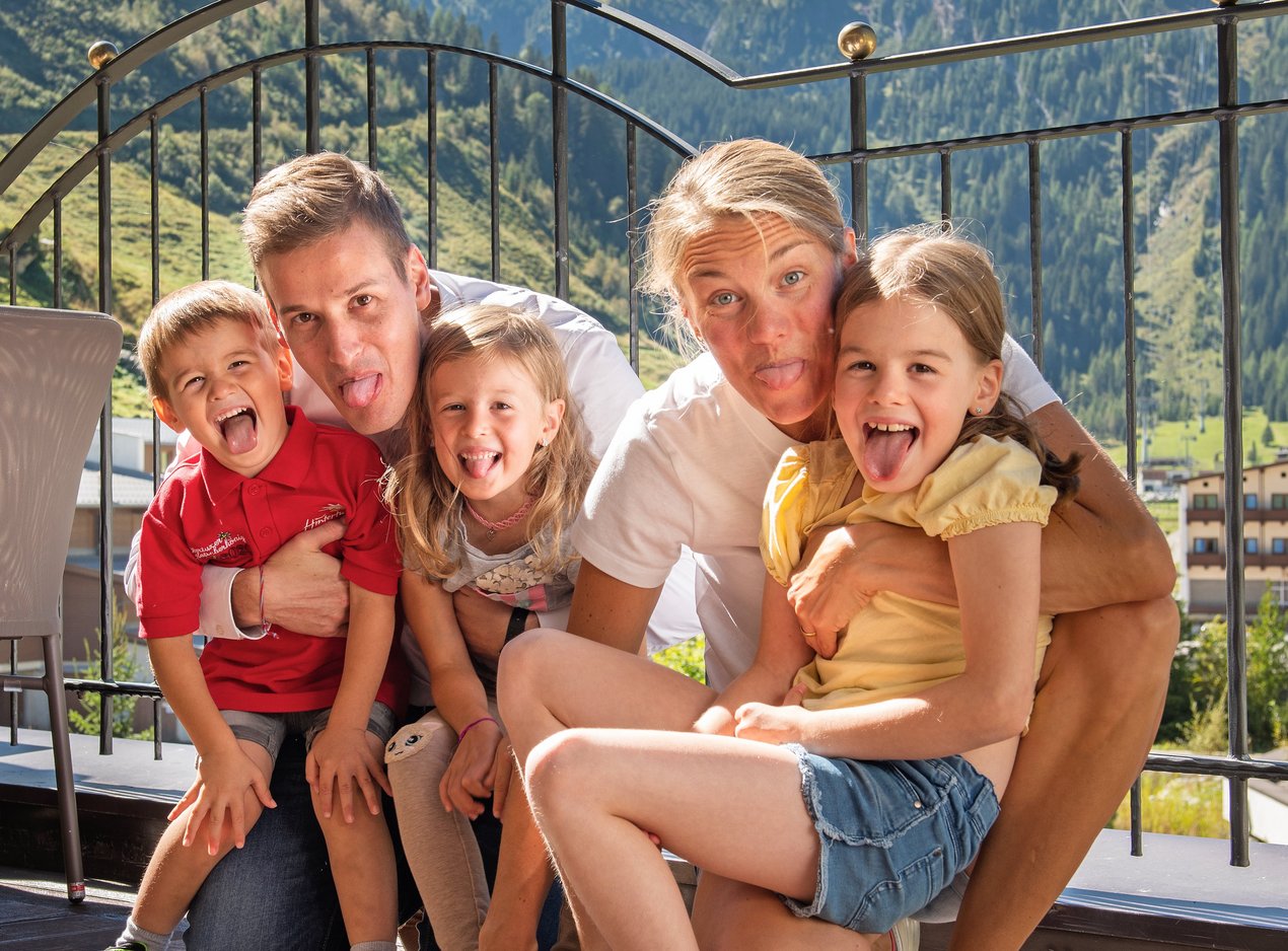 Familie Dengg posiert im Sommer vor Bergkulisse