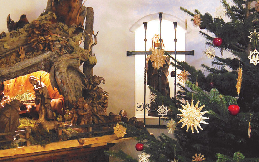 Die Krippe zeigt eine lebendige Szene mit Hirten und Tieren, umgeben von einer warmen, einladenden Atmosphäre während der Weihnachtszeit.