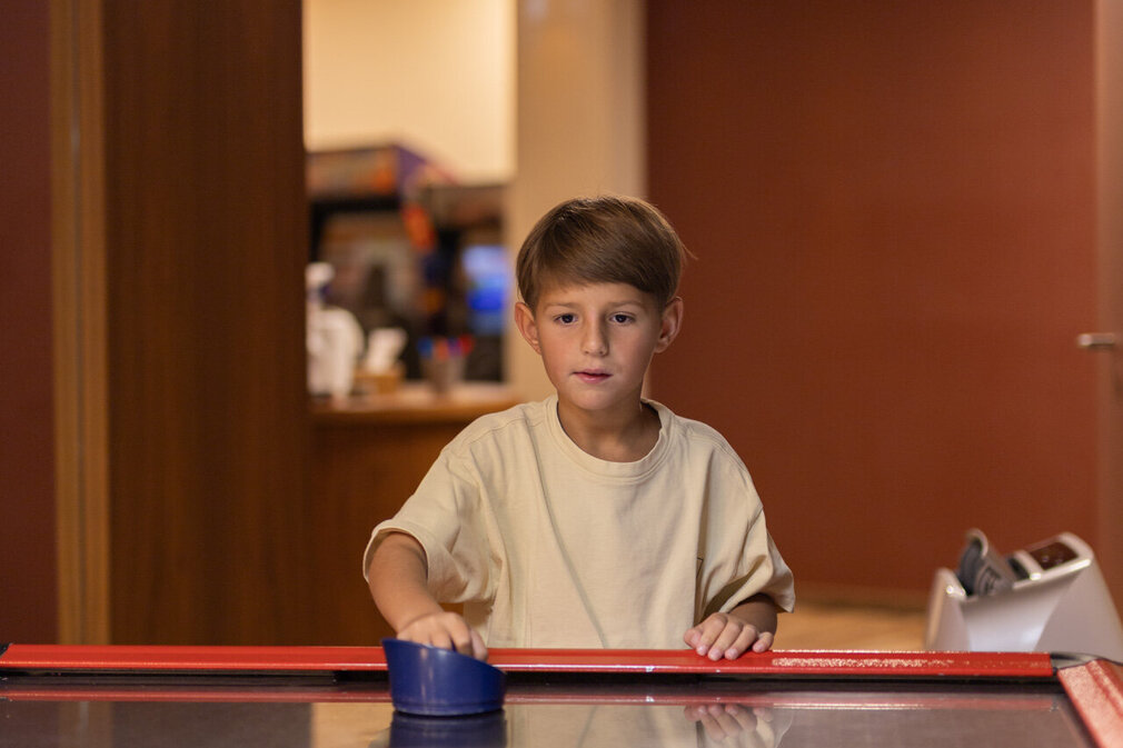 Ein Junge spielt Airhockey.