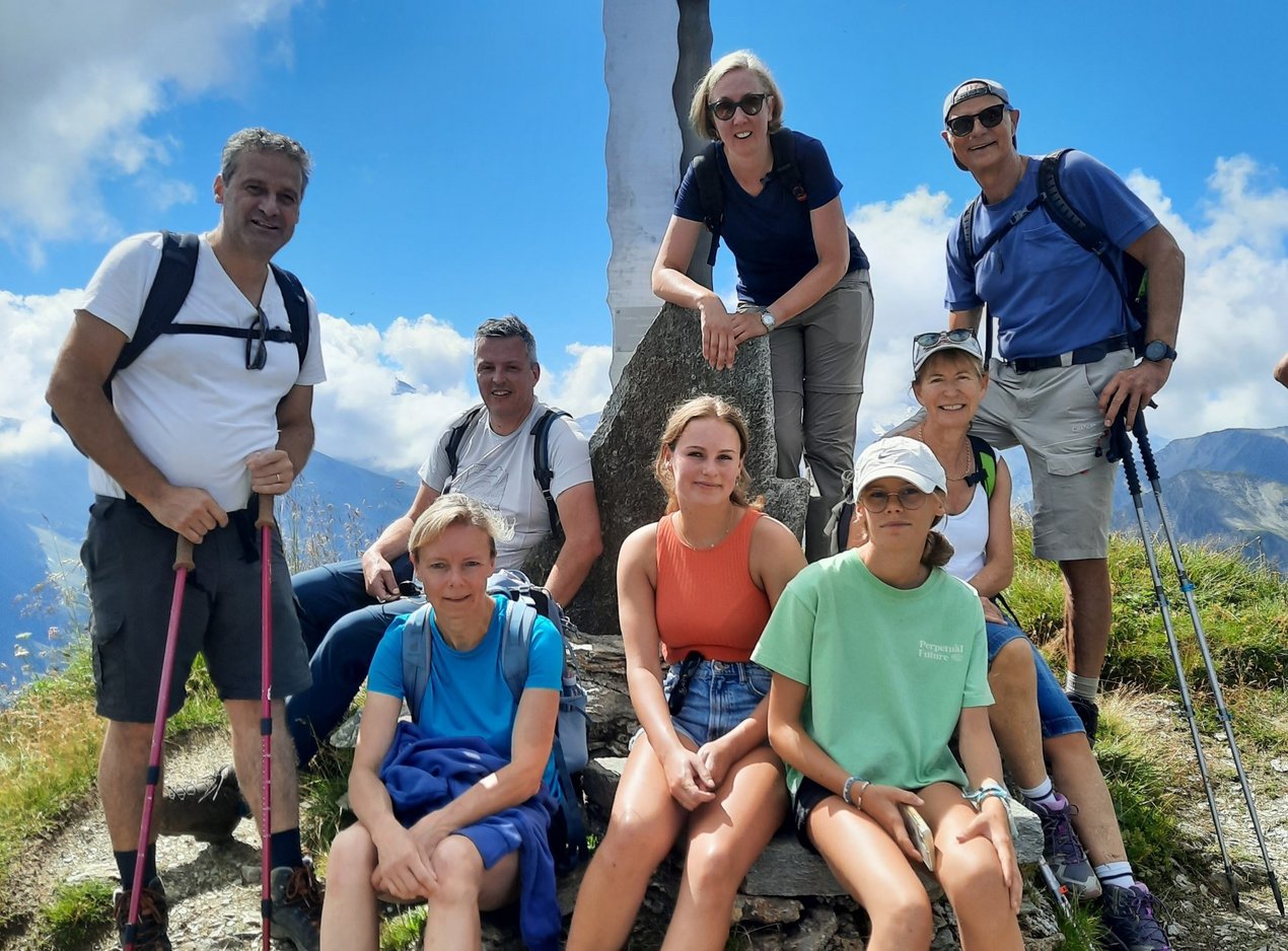 Menschen versammelt für ein Gruppenfoto auf einem Berggipfel