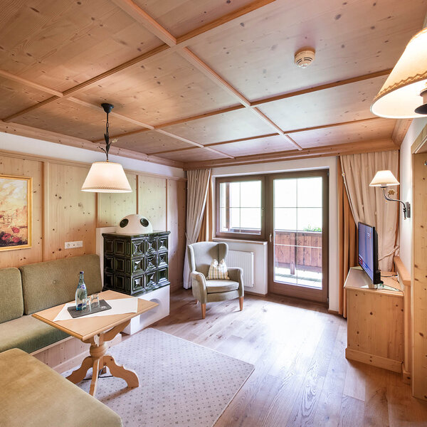 Ein gemütliches Wohnzimmer mit Holzverkleidung, einem grünen Sofa und einem kleinen Tisch, ideal für entspannte Abende.