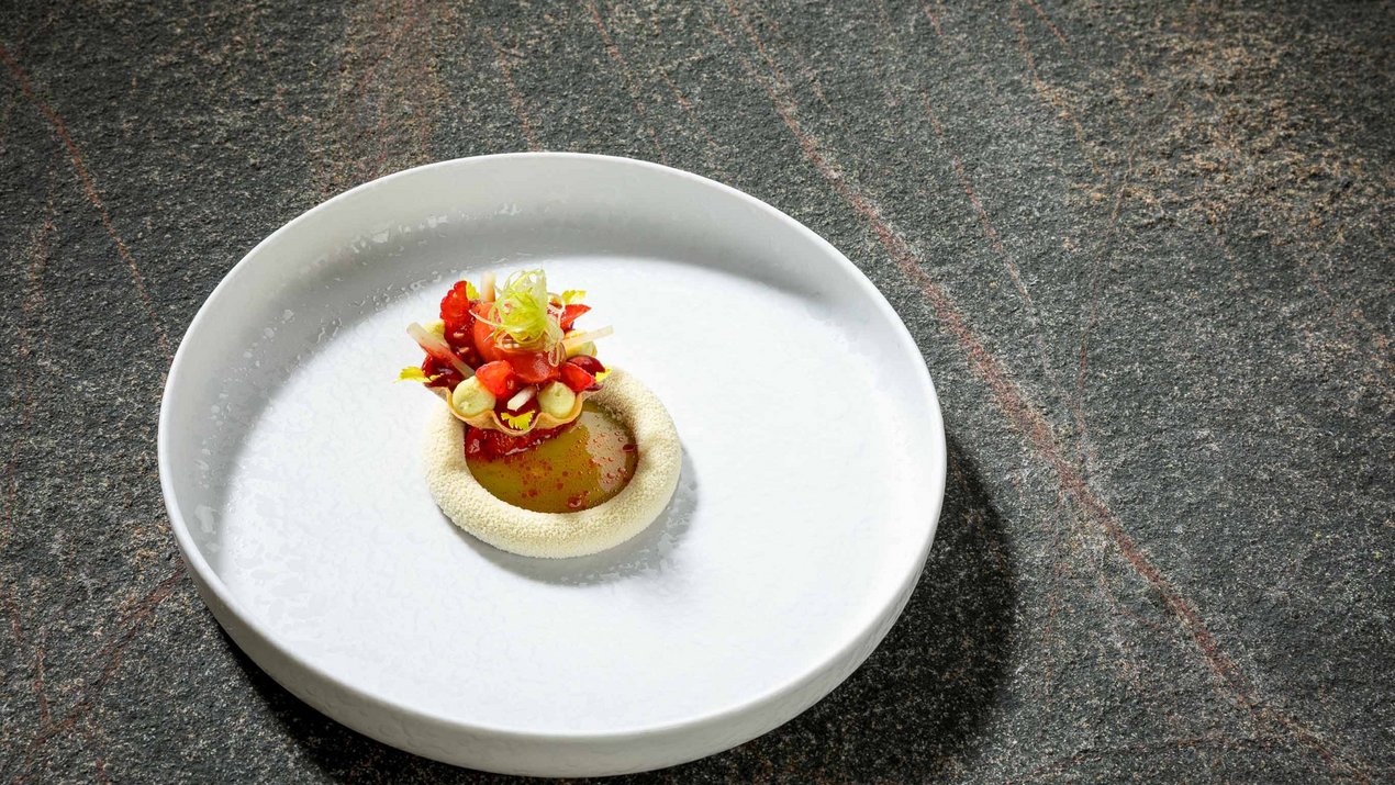 Kreatives Gericht aus roten und grünen Lebensmitteln auf weißem Teller serviert