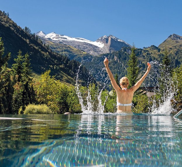 Frau im Schwimmbad vor Bergpanorama